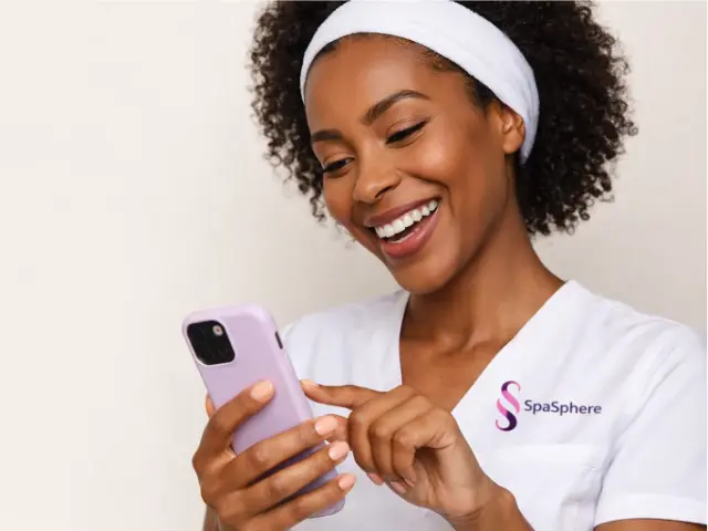 Esthetician using SpaSphere on her phone